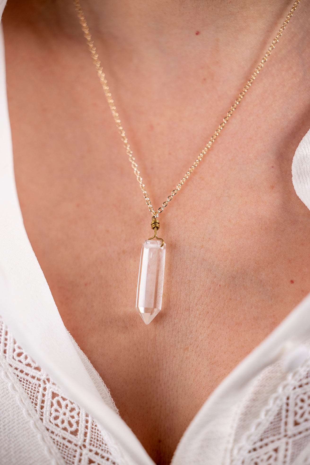 Cristal de roche monté sur une chaîne dorée, pendentif artisanal, idéal pour un look raffiné et intemporel.