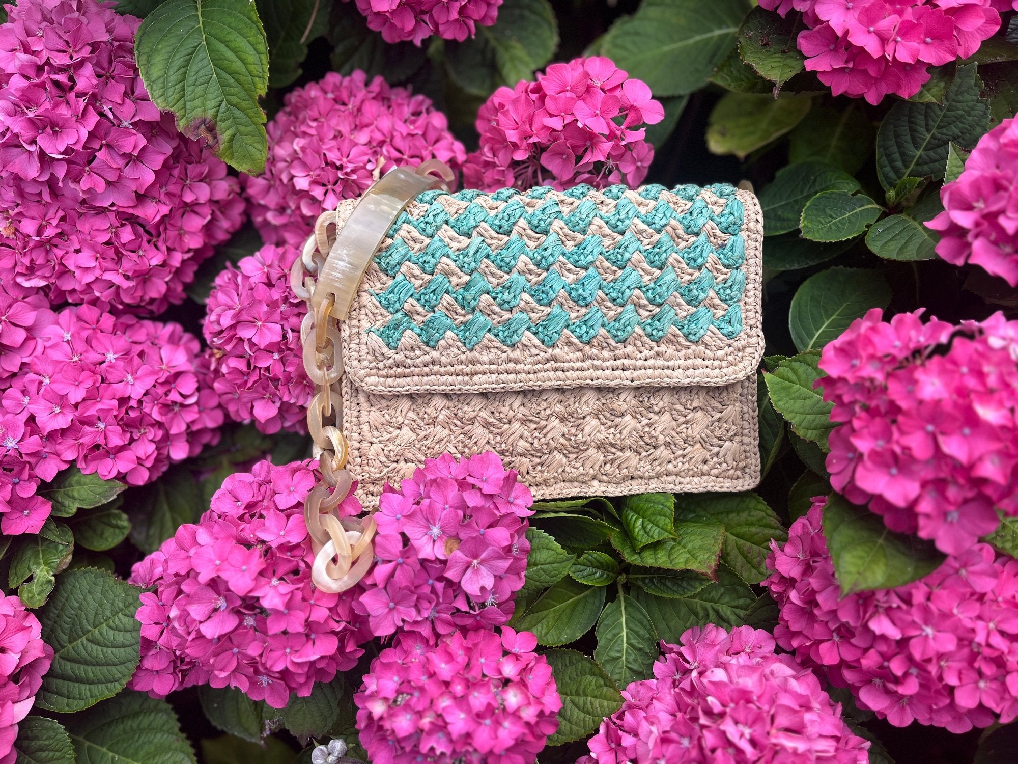 Sac artisanal en raphia avec ornement en corne, turquoise, design unique et élégant, idéal pour compléter vos tenues.