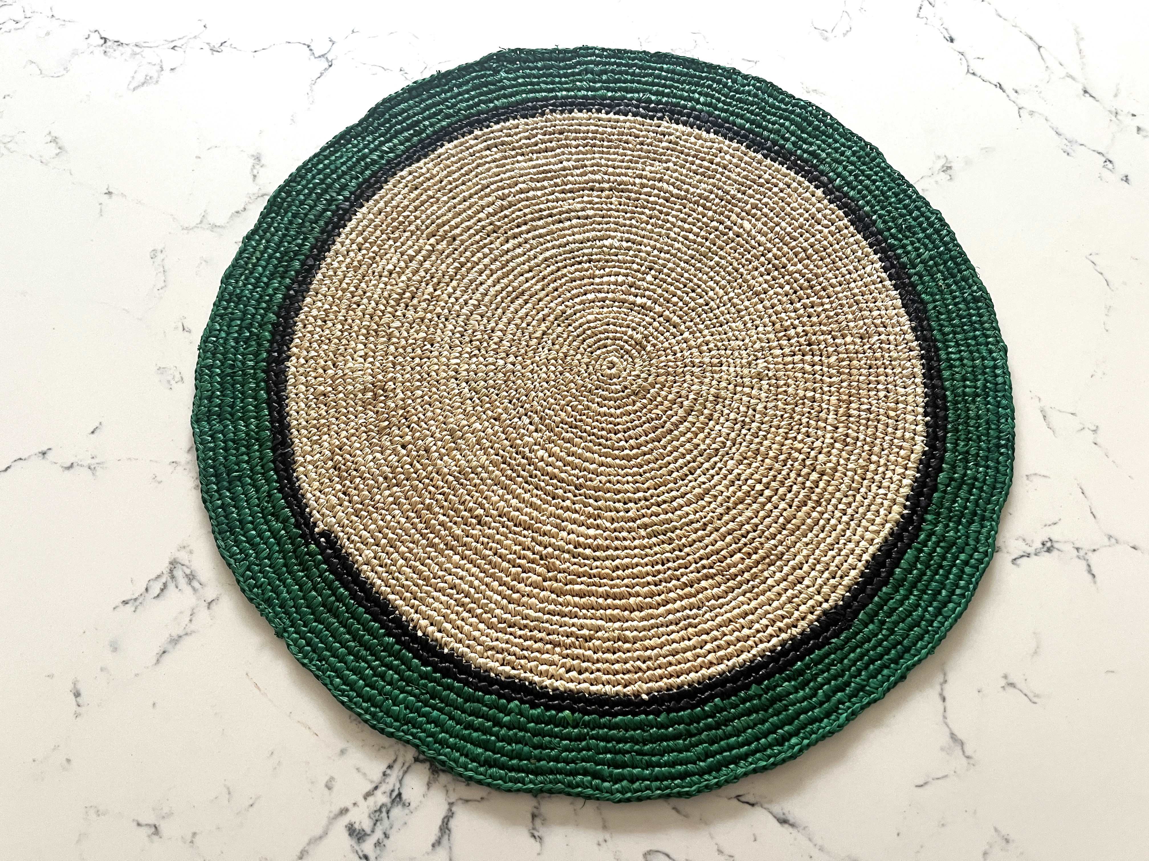 6 sets de table ronds en raphia naturel, bordures vert émeraude, faits main, idéals pour une ambiance naturelle et élégante.