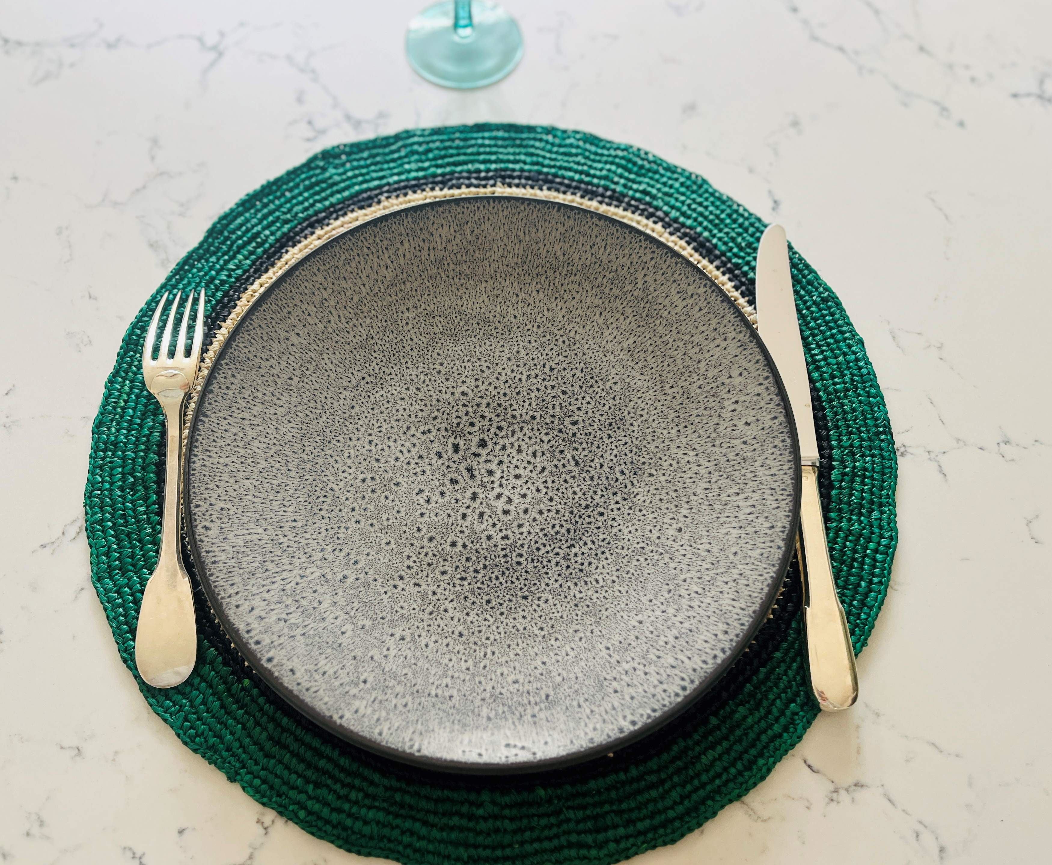 Lot artisanal de 6 sets de table ronds en raphia naturel, finition vert émeraude, parfaits pour une décoration élégante.