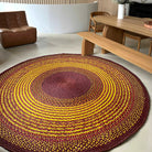 Tapis artisanal rond en raphia aux couleurs jaune, brun et prune, fabriqué à Madagascar, diamètre 230 cm.