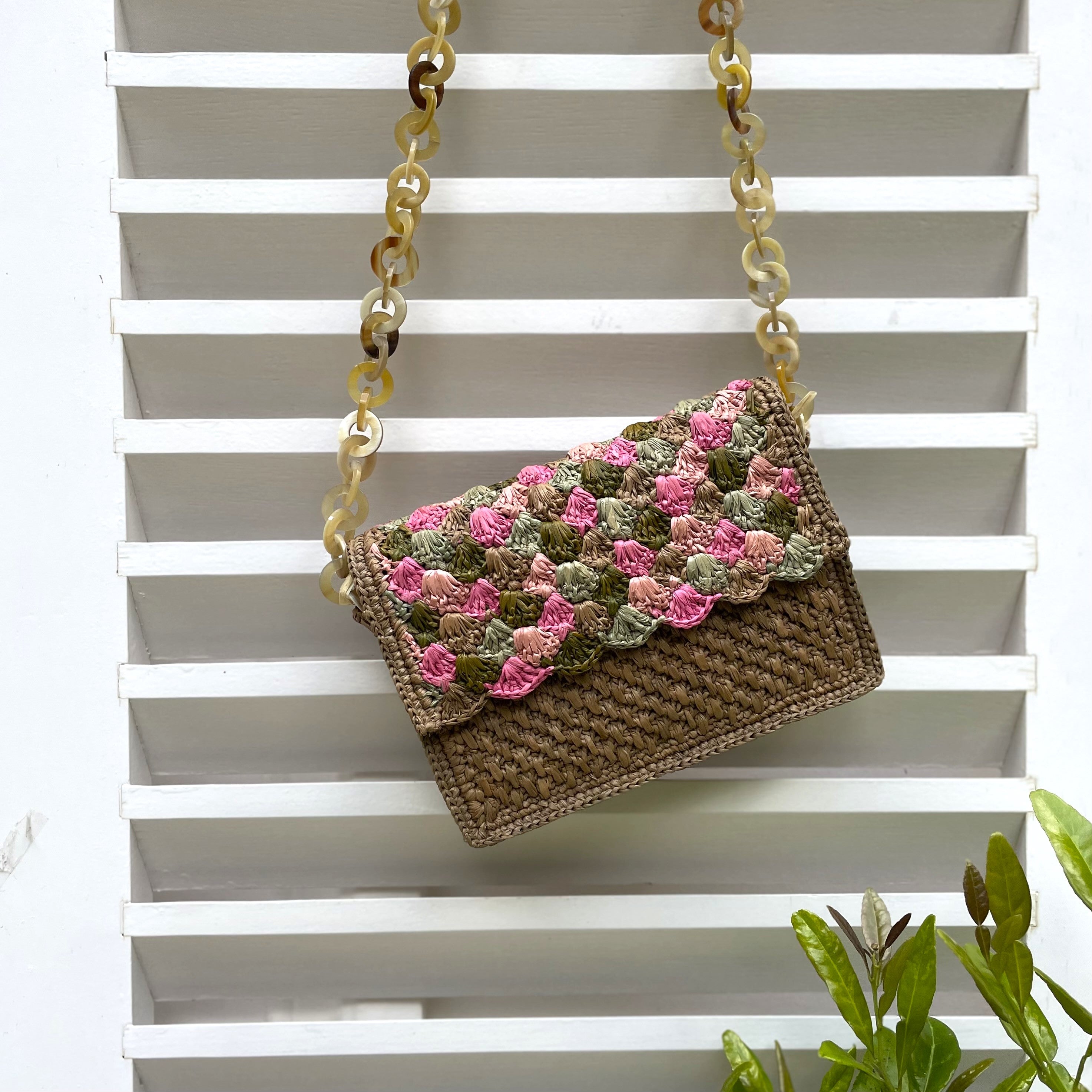 Sac à main en raphia kaki et rose, design unique avec chaîne en corne, fait main, idéal pour une allure naturelle et élégante.