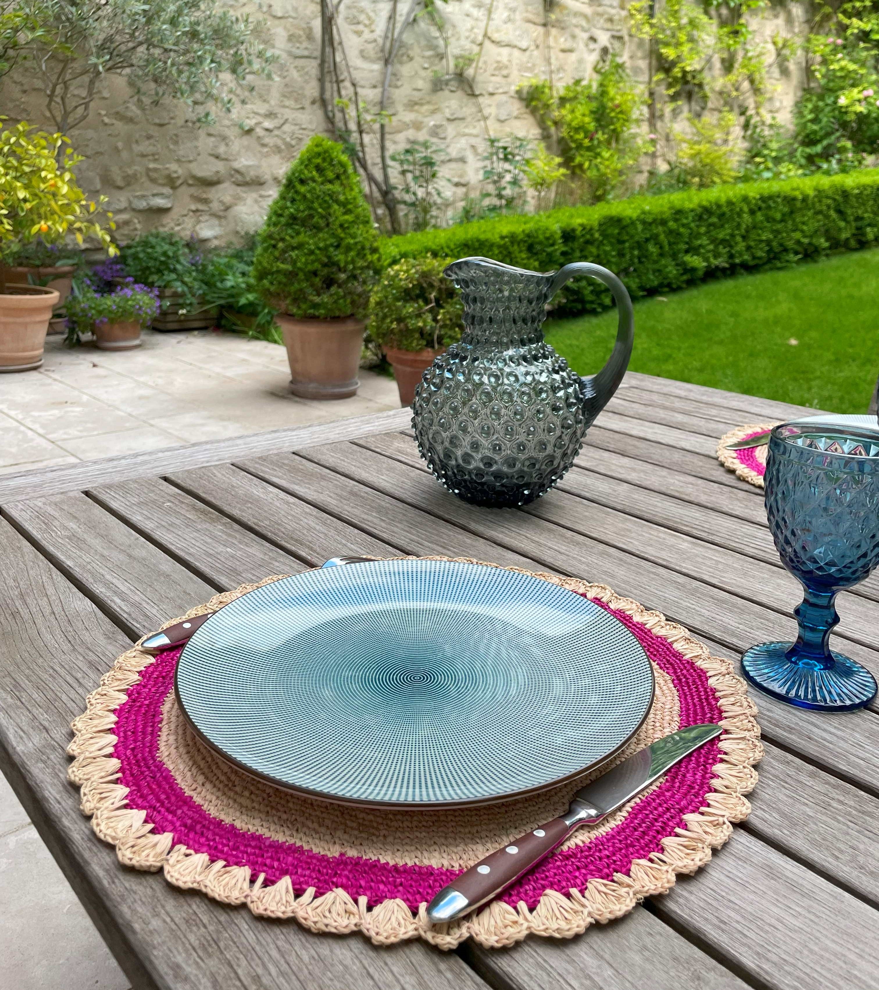 Sets de table en raphia naturel avec bordure rose, faits main, parfaits pour une décoration de table fraîche et colorée.