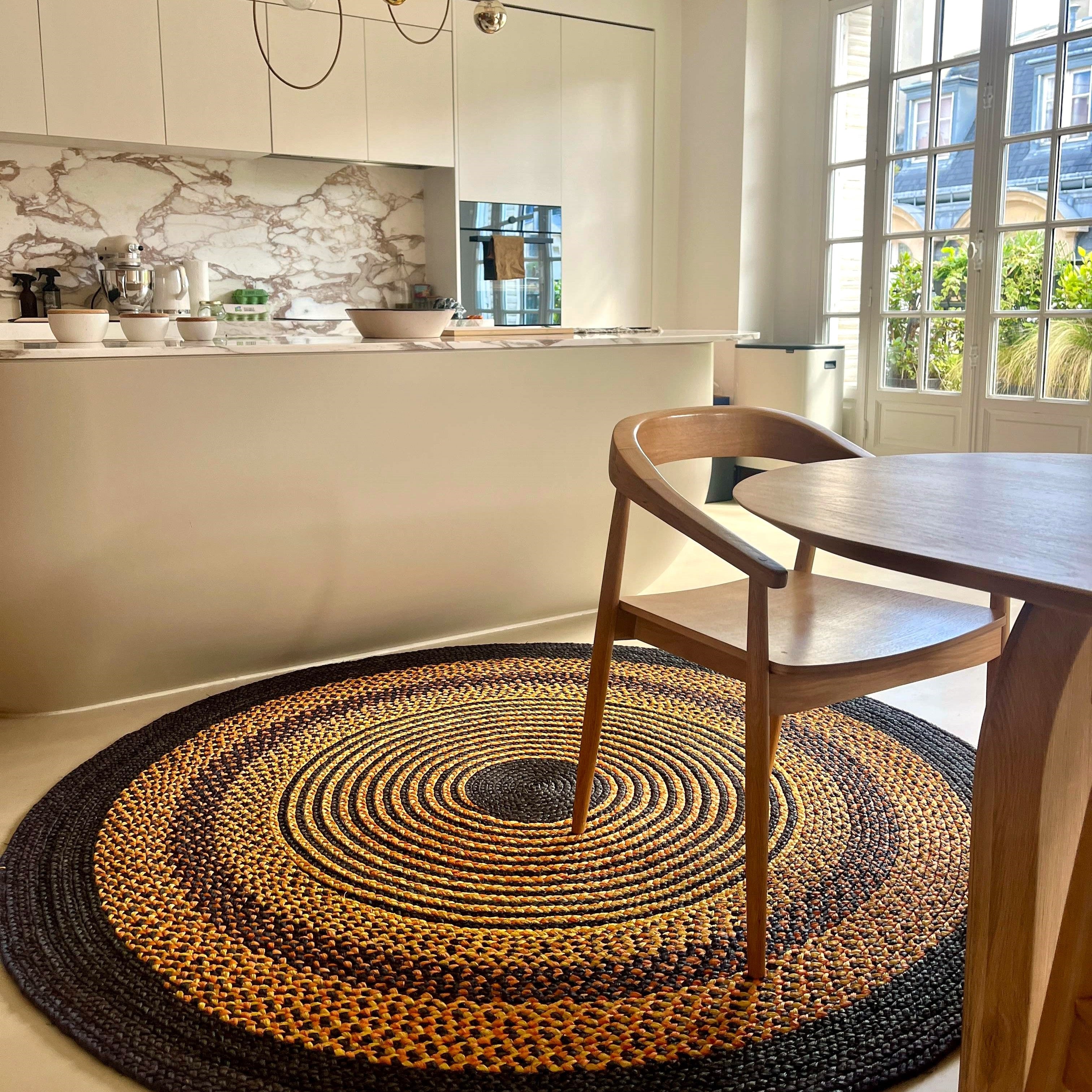 Tapis en raphia rond noir, jaune et terracotta, fait main à Madagascar, dimensions 200 cm, idéal pour une touche naturelle.