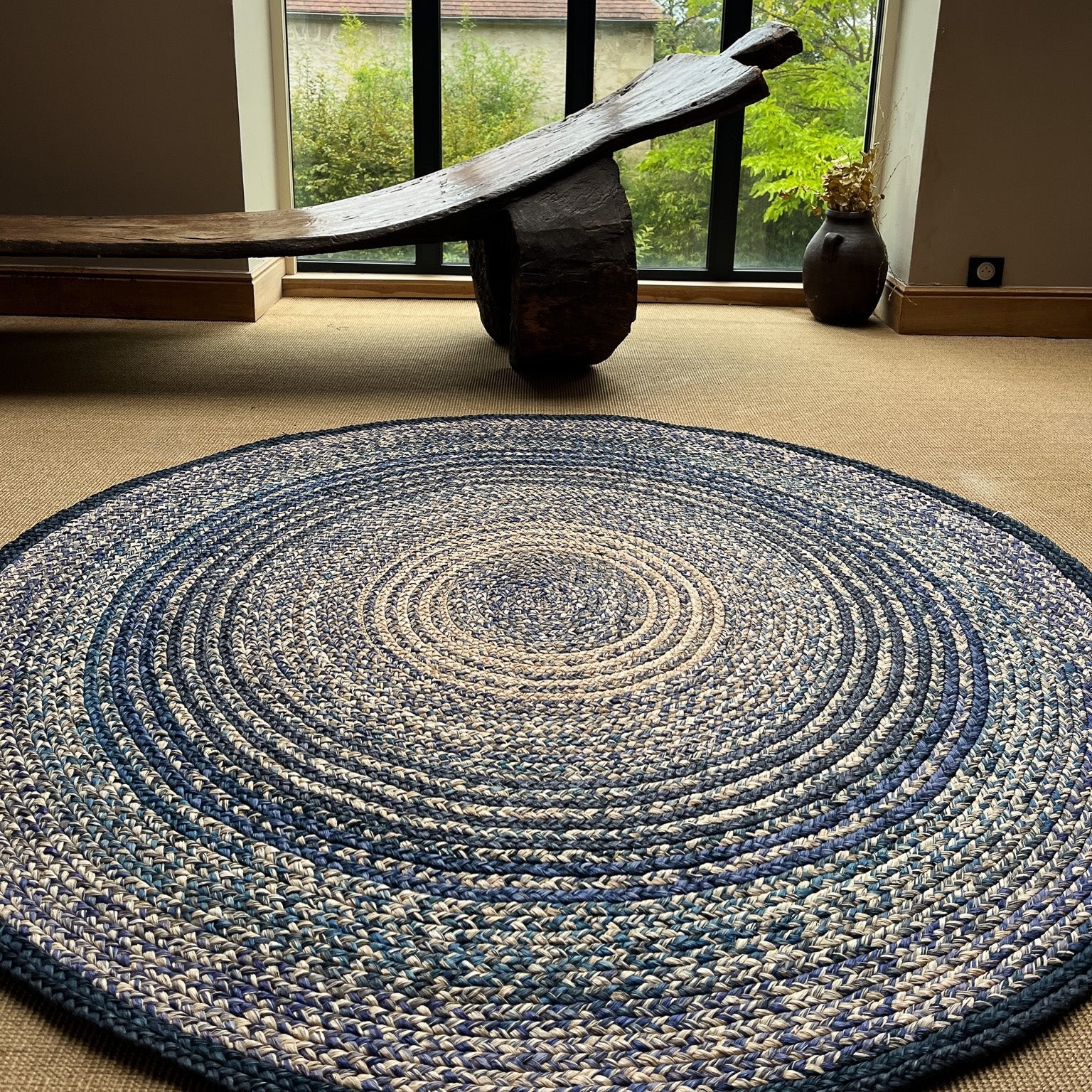 Tapis artisanal en raphia rond bleu marine et naturel, 170 cm, idéal pour un intérieur chaleureux.