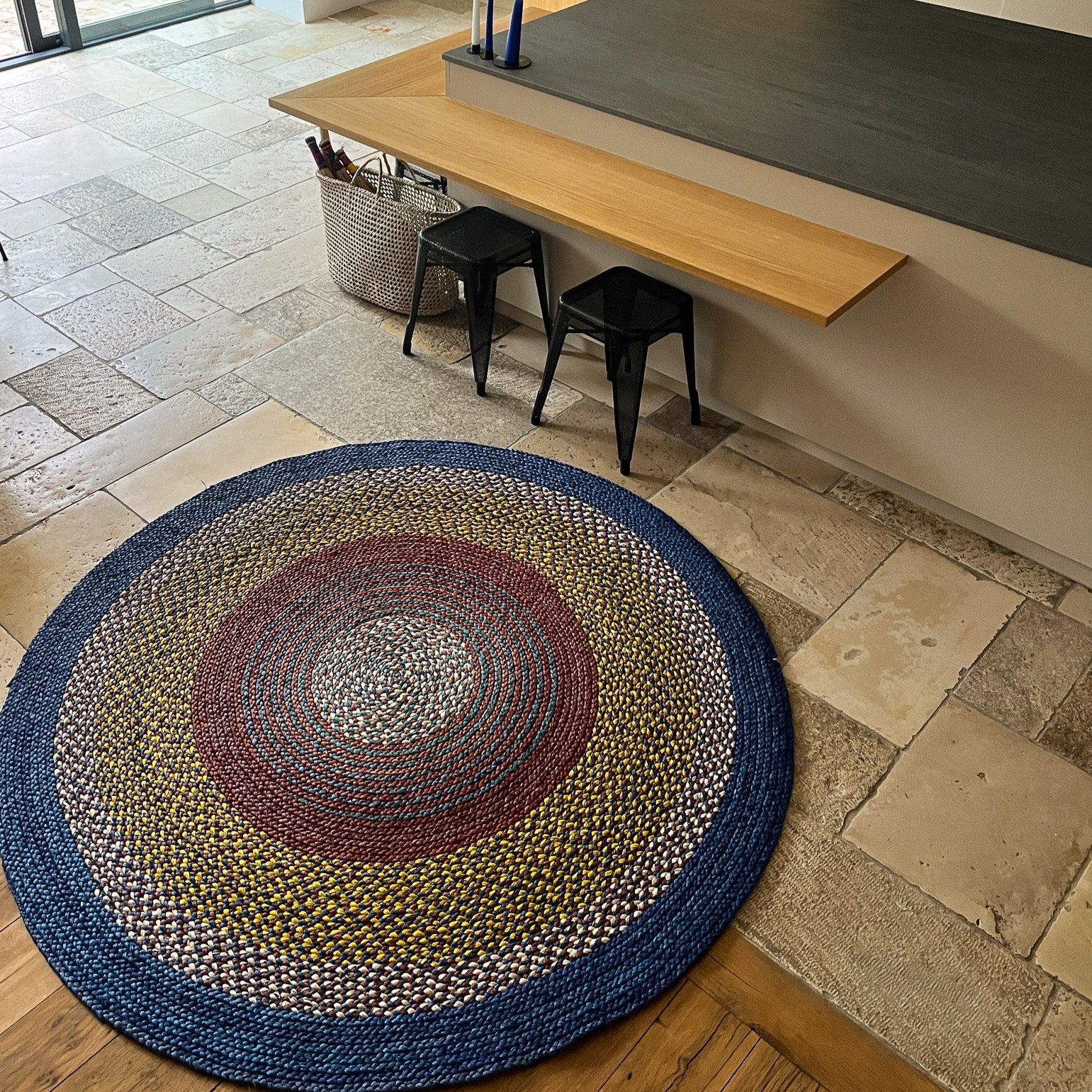 Tapis artisanal rond en raphia rouge bordeaux, jaune, naturel et bleu, 180 cm.