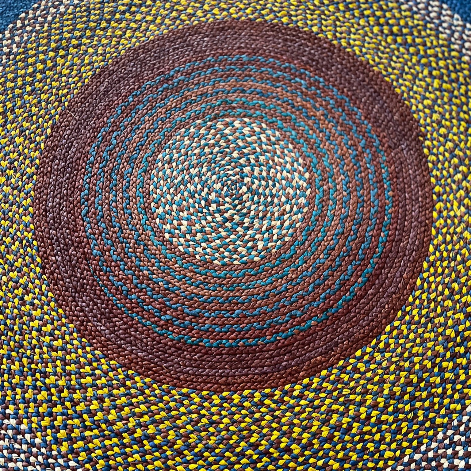 Tapis rond en raphia, couleurs rouge bordeaux, jaune, naturel et bleu, diamètre 180 cm.